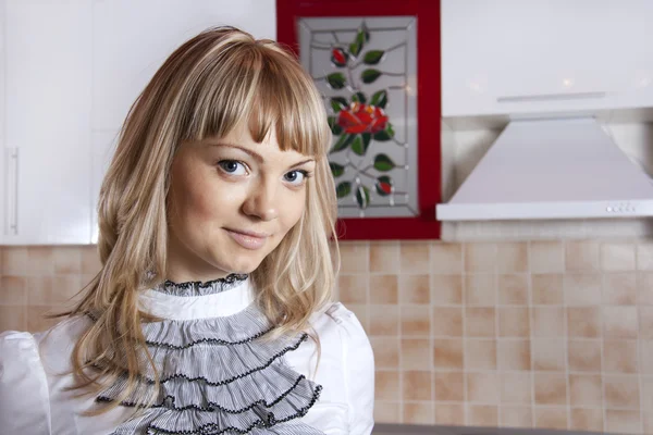 Giovane donna in cucina in colore rosso-bianco — Foto Stock