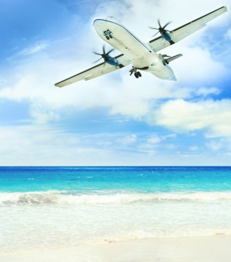 Airplane landing over the tropical lagoon at sunny day clipart