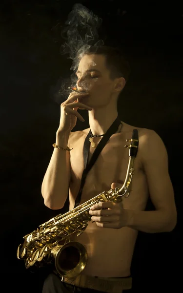 Fumo giovane jazz man con sassafono — Foto Stock
