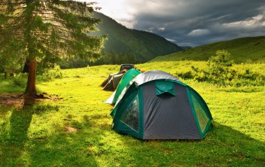 Tourist tents on the glade at sunset clipart