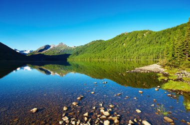 Mountain landscape with still lake and reflection clipart