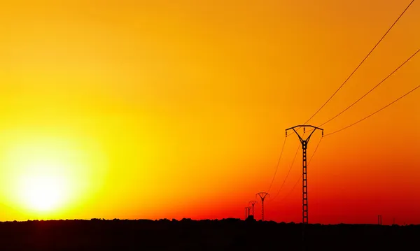 Elektrische hoogspanningslijn tegen kleurrijke lucht bij zonsondergang — Stockfoto