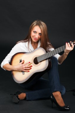 bir gitar üzerinde siyah bir arka plan ile çekici bir kadın portresi