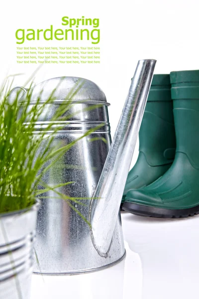Trädgårdsredskap och vattenkanna med gräs på vit — Stockfoto