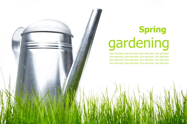 Rega pode com grama e ferramentas de jardim em branco — Fotografia de Stock