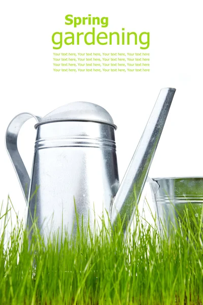 Gießkanne im Gras mit weißem Hintergrund — Stockfoto