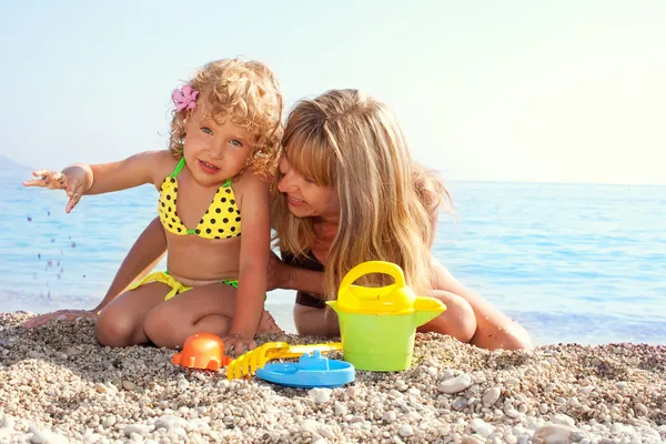 漂亮的小女孩跟妈妈在海滩上 — 图库照片