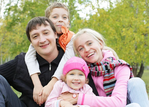 秋の公園で二人の子供と幸せな家族 — ストック写真