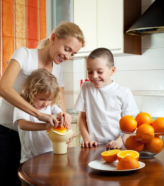 快乐妈妈与孩子榨橙汁 — 图库照片