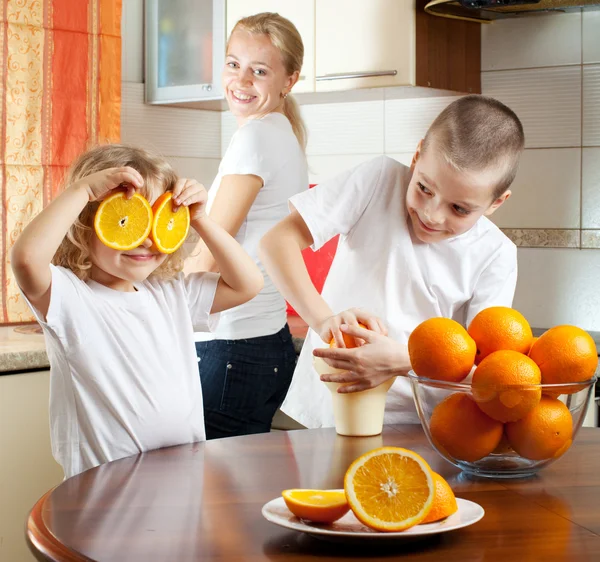 Mutter mit Kindern presste Orangensaft — Stockfoto