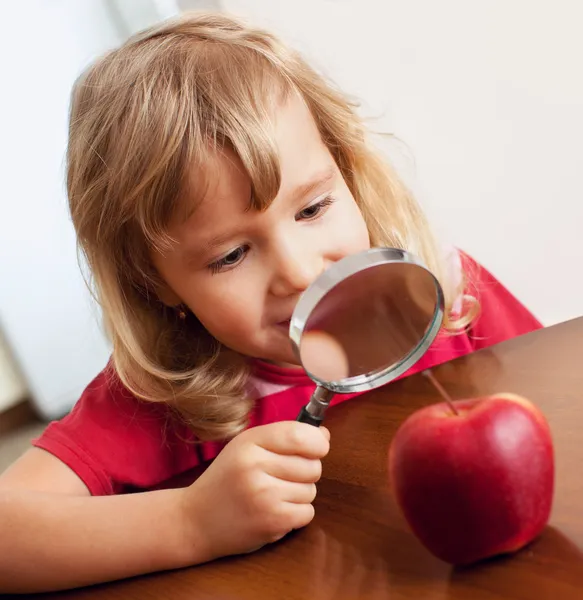 Çocuk bir büyüteç apple dikkate alınarak — Stok fotoğraf