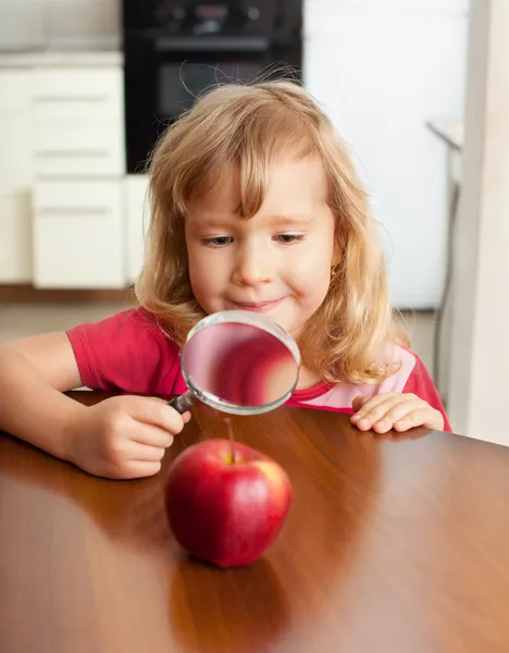 Παιδί εξετάζουν ένα μεγεθυντικό φακό μήλο — Φωτογραφία Αρχείου