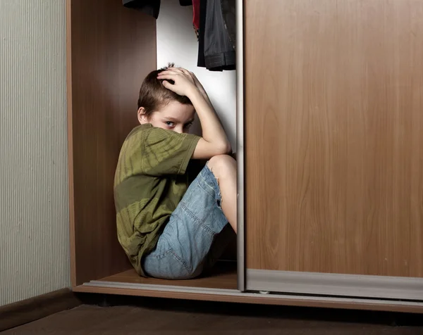 Trauriger Junge, versteckt im Schrank — Stockfoto