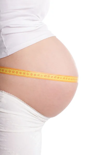 Těhotná žena měřící pás — Stock fotografie
