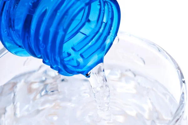 Бутылка наливая воду в стекло — стоковое фото