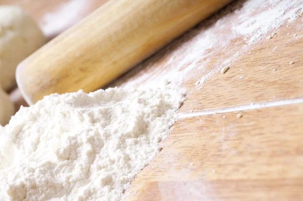 Ręce zbliżenie mąki wyrabiania ciasta na stół — Zdjęcie stockowe
