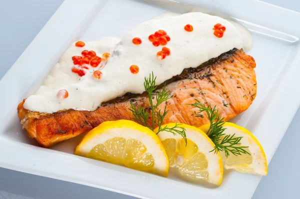 Steak from a salmon with creamy sauce and caviar — Stock Photo, Image