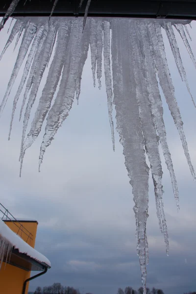 Çatıda Gökyüzü Arka Plan Üzerinde Cols Kışın Buz Sarkıtları — Stok fotoğraf
