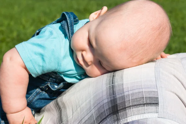 Um menino deitado de costas com o pai — Fotografia de Stock