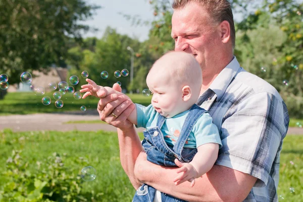 Dad and son look at the bubbles — Stock Photo, Image