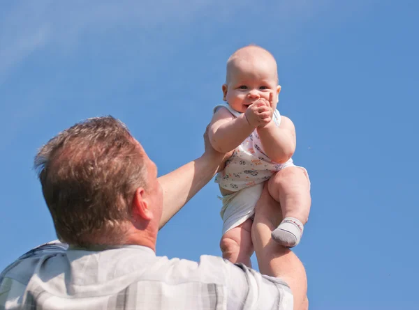 Father lifted up her baby, the child is happy — Stock Photo, Image