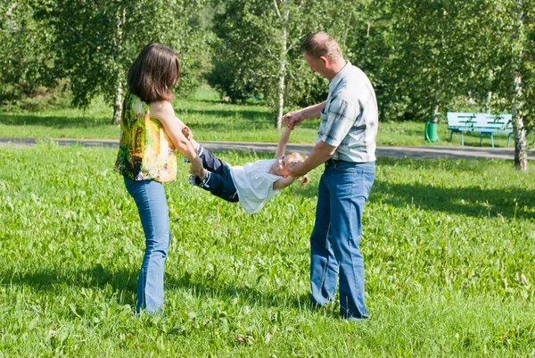 Mamma och pappa spela med sin dotter, skaka hennes hand — Stockfoto