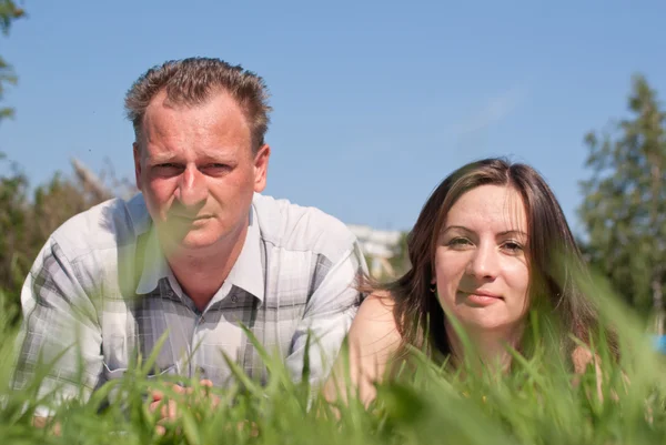 Portrait of a woman and a man lying on grass — Stock Photo, Image