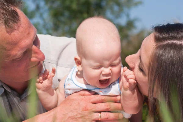 Porträtt av lycklig mor och far med en baby — Stockfoto