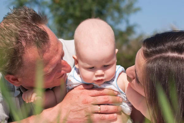Porträtt av lycklig mor och far med en baby — Stockfoto