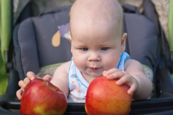 Маленька дитина тримає обидві руки два яблука — стокове фото