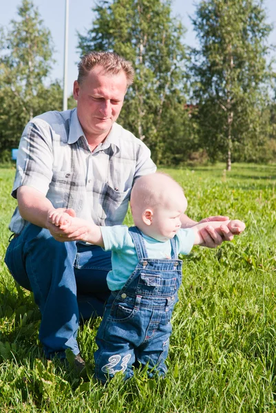 Tata uczy dziecko, aby przejść przez uchwyty — Zdjęcie stockowe