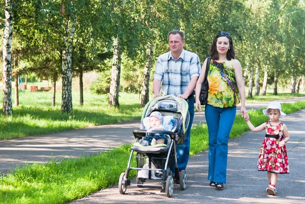 Ευτυχισμένη οικογένεια περπατά στο πάρκο Φωτογραφία Αρχείου