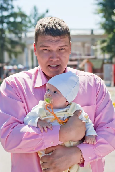 Far promenader med sin baby i famnen — Stockfoto
