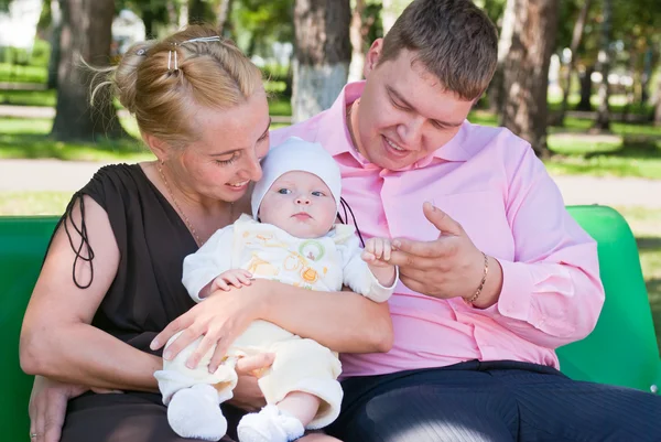 Porträtt av en lycklig familj i en sommar park — Stockfoto