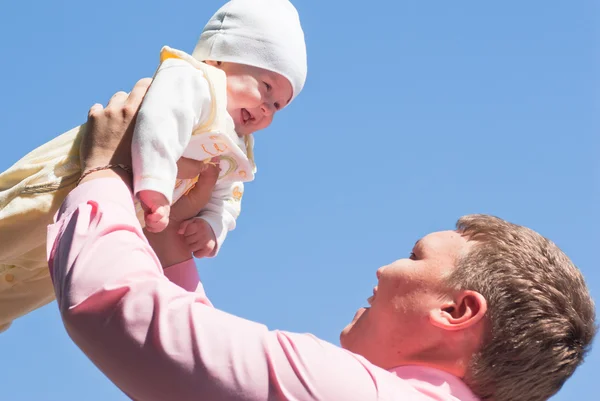 L'uomo innalza il suo bambino sopra di lui — Foto Stock