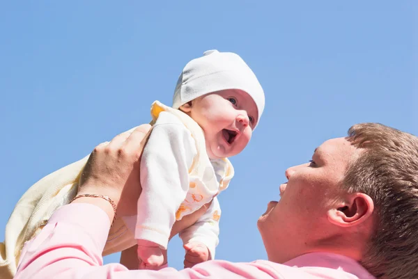 Dad picks up her child high above him — Stock Photo, Image