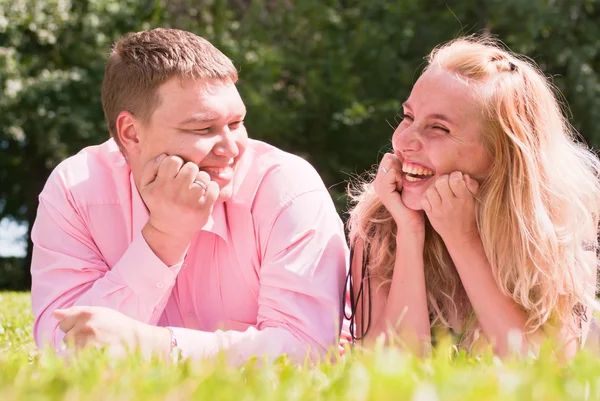 Feliz joven pareja acostada en la hierba —  Fotos de Stock