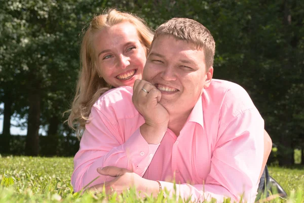 Feliz joven pareja acostada en la hierba —  Fotos de Stock
