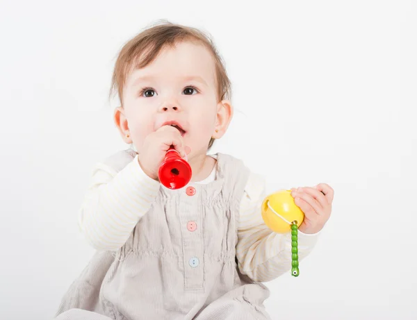 The little girl plays with wooden toys a white background — Stock Photo, Image