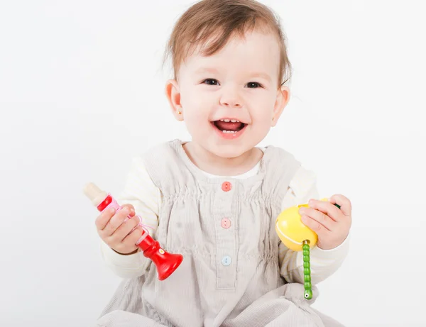 La niña juega con juguetes de madera un fondo blanco —  Fotos de Stock