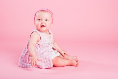 Portrait of the small beautiful joyful girl on a pink background clipart
