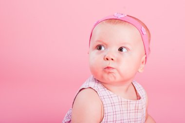 Portrait of the beautiful serious girl on a pink background clipart