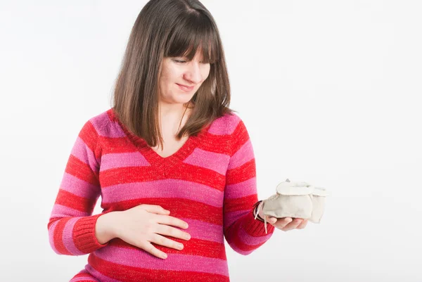 Έγκυος Γυναίκα Εξετάζει Των Παιδιών Παντόφλες Του Μωρού Όνειρα — Φωτογραφία Αρχείου