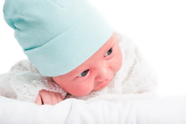 Новорожденный ребенок в синей шляпе на подушке — стоковое фото