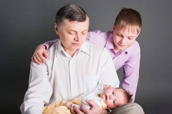 Vater und Bruder schauen sich das neugeborene Kind an — Stockfoto