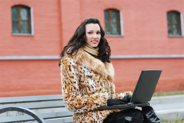 Brunette with laptop outdoors — Stock Photo, Image