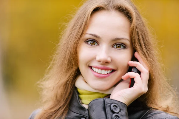Young woman talks on cellular telephone — Stock Photo, Image