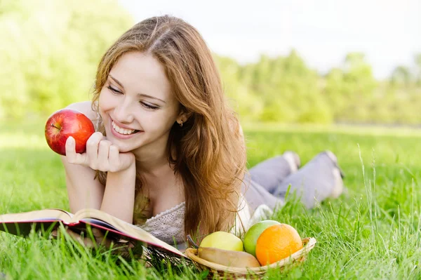 Mädchen mit Buch und Äpfeln — Stockfoto