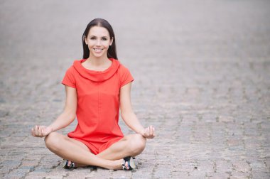 Woman in red dress meditates clipart