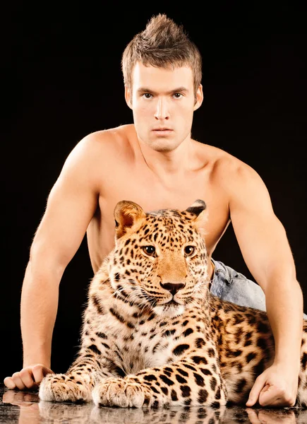 Young man and spotty leopard — Stock Photo, Image